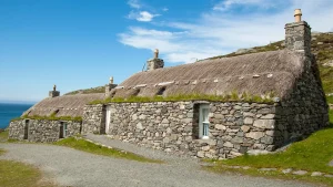 Traditional stone thatched cottage overlooking the sea on the Isle of Lewis, Scotland.