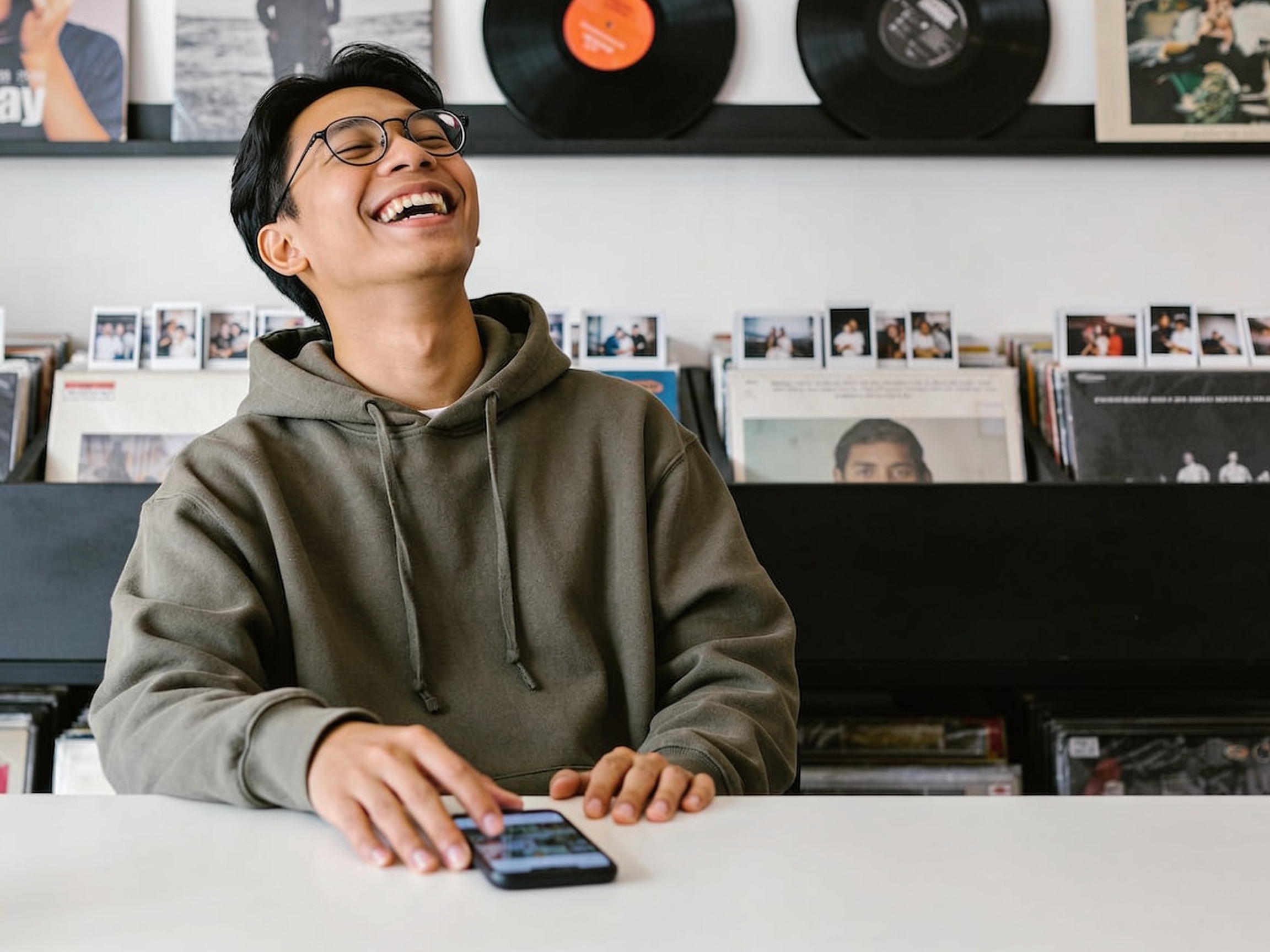 Young Indonesian adult analyzing the impact of pop culture trends on a smartphone screen